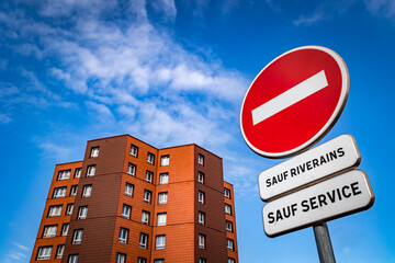Immeuble contemporain sur fond de ciel bleu avec panneau ses interdit