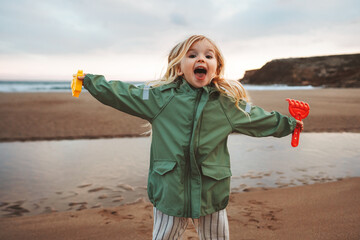 Child playing outdoor family lifestyle vacations girl happy smiling walking with toys on the beach