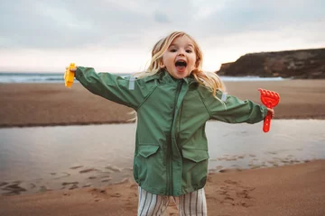 Foto auf Alu-Dibond Child playing outdoor family lifestyle vacations girl happy smiling walking with toys on the beach © EVERST