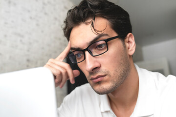 Close up portrait of shocked man looking at laptop	