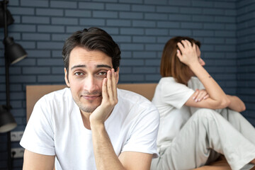 Portrait of cheating husband imitating erectile dysfunction and refusing his wife