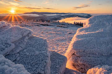 Wintermood sunrise in a mountains with frozen stones and spruce trees with inversion in Jeseniky...