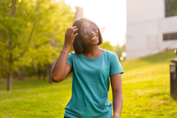Forest Retreat: Lifestyle Portrait of a Black Female Tourist with Sunglasses at Sunset in the Woods