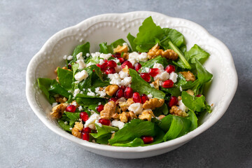 Arugula salad with cheese served with walnuts and pomegranate. Turkish name; Roka salatasi