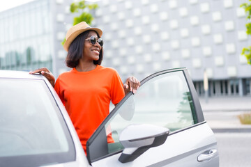 Naklejka premium Adventures in the city: black woman with sunglasses and orange shirt getting into car