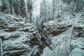 snowy mountain park with creek between rocks