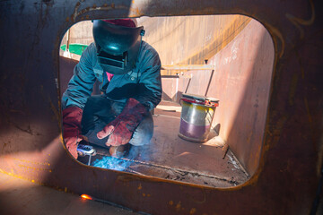 Male worker wearing protective clothing and repair pontoon manhole welding industrial construction...