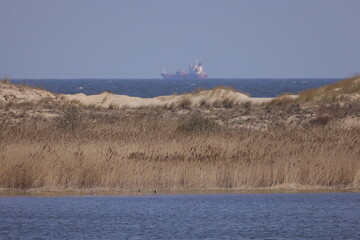 Ship at sea with horizon with wild natural terrain