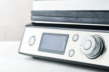 Electric grill. Modern kitchen portable grill tool for modern kitchen for grilling meat, vegetables and snacks for dinner or party on light gray background. Place for text or advertisement. Mock up.