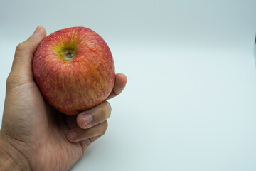 hand holding red apple, Isolated on a white background.