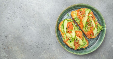 Open sandwiches with salted salmon, guacamole avocado and fresh greens. Delicious breakfast or snack, Clean eating, dieting, vegan food concept. top view.