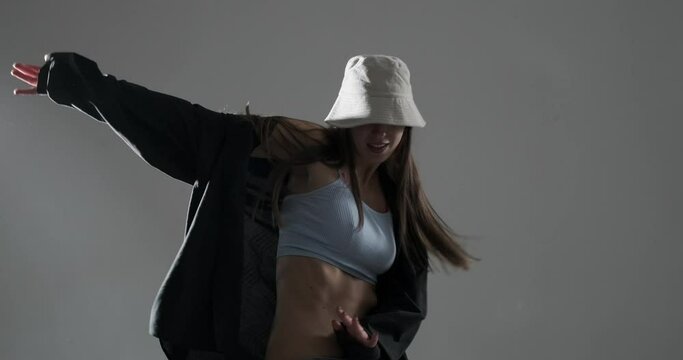 Stylish young woman dancing hip hop freestyle in hat on studio background Generative AI