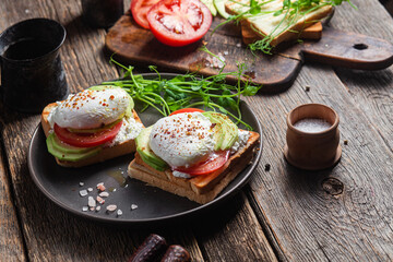 Toast with poached egg, tomatoes and avocado. Healthy breakfast