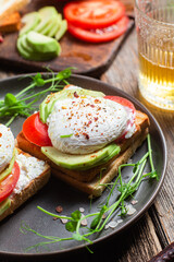 Toast with poached egg, tomatoes and avocado. Healthy breakfast
