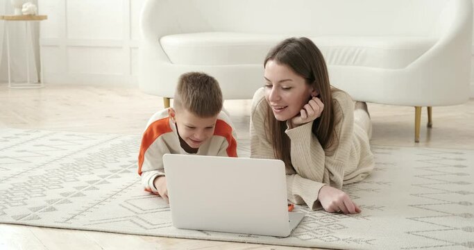 Mother talking with her son lying down and using laptop at home Generative AI