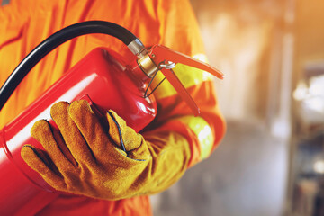 hand presses the trigger fire extinguisher available in fire emergencies conflagration damage...