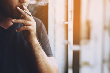 Fototapeta na wymiar man holding smoking a cigarette in hand. Cigarette smoke spread. dark background