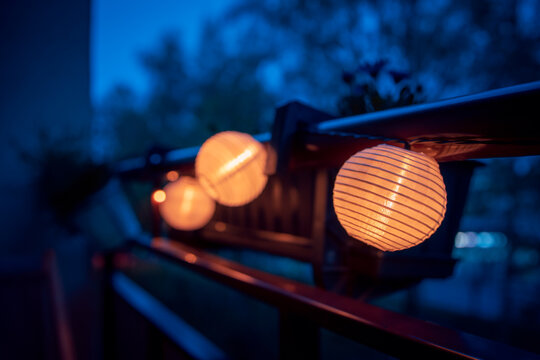 A lighted garland with solar lamps hung on the balustrade of the balcony. Mood light. Evening