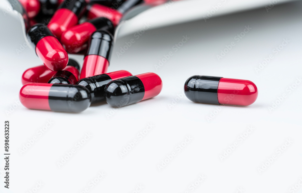 Wall mural red-black antibiotic capsule pills with blur drug tray on white table. antibiotic drug smart use. pr