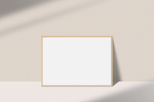 Realistic landscape photo frame mockup. Wooden frame mockup on the table with light window shadow overlay effect. Simple, clean, modern, minimal empty poster frame mock up. White picture frame mockup