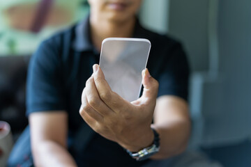 Man holding device and touching screen on smartphone.