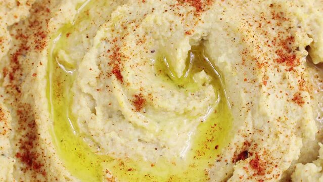 Top view of chickpea hummus with olive oil and smoked paprika circle rotation close up. Healthy vegan food