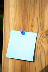 purple map pin and blue square paper note on a natural orange piece of wood with empty free space for template or blank copy area