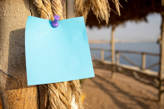 rope with wooden post and a blue square paper note with empty free space for template or blank copy area 