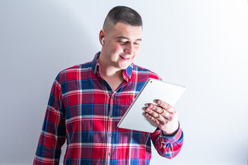A young man holds a modern tablet in his hands