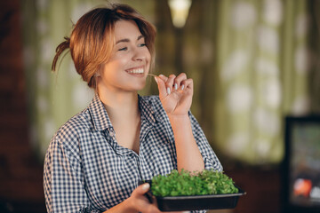 smiling woman eats microgreens