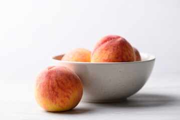 Ripe Peaches fruit in bowl on white table