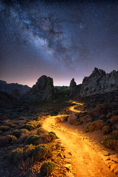 Night time image of the Roque de Garcia with illuminated hiking path and Milky way galactic center stars on Tenerife, Spain
