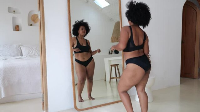 Attractive plus-size black woman dances in front of mirror in underwear enjoying her life and beauty of her own body. Positivity, love and acceptance of fat and overweight. Diversity of Generative AI