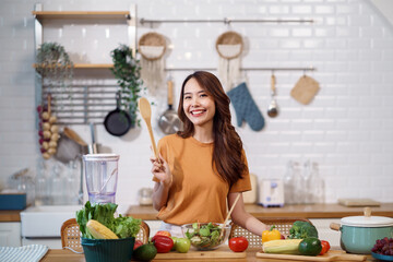 Young Asian woman is preparing a fresh healthy vegan salad with many vegetables in the kitchen, Dieting Concept. Healthy food Lifestyle. Cooking At Home.