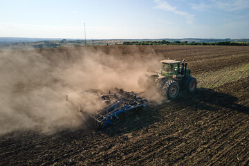Aerial view of tractor plowing agriculural farm field preparing soil for seeding in summer © bilanol