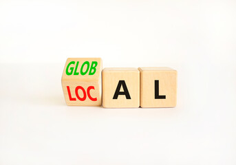 Local or global symbol. Businessman turns wooden cubes and changes the word Local to Global. Beautiful white table white background. Business and local or global concept. Copy space.