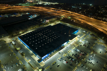 View from above of many parked cars on illuminaded parking lot with lines and markings for parking...