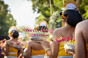 Gordijnen Procession of beautiful Balinese women in traditional costumes - sarong, carry offering on heads for Hindu ceremony. Arts festival, culture of Bali island and Indonesia people, Asian travel background © Tropical studio