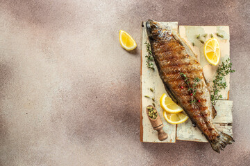 Grilled spicy fish on a wooden board. Restaurant menu, dieting, cookbook recipe top view