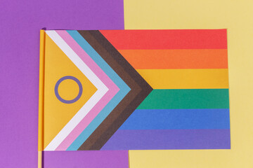 Flat lay Lgtbiq+ flags banner on light yellow and purple background