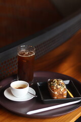 Close up a cup of coffee and bakery on wooden table background