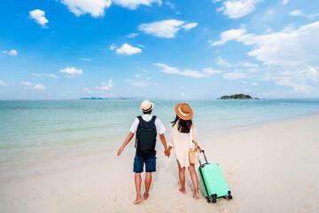 Young couple traveler with luggage relaxing and enjoying at beautiful tropical sand beach, Summer...