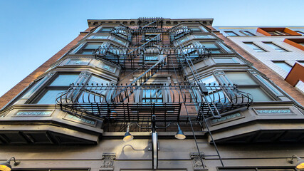 The facade of a quaint old apartment building contrasts with the modern facade of the structure...