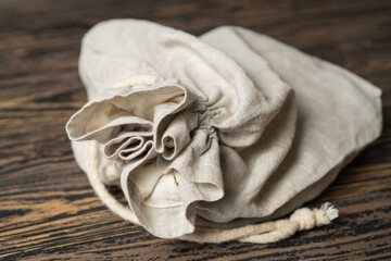 Beautifully crafted linen bread bag on brown table. Gray organic cotton bread bag.