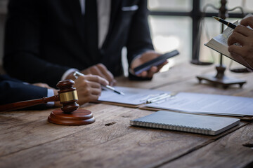 justice and law concept. male lawyer working in an office. Legal law, advice, and justice concept. The client is bringing the documents to clarify the law to the lawyer at the prosecutor's office.
