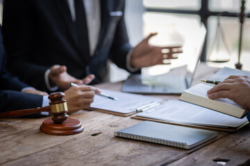 Fototapeta premium justice and law concept. male lawyer working in an office. Legal law, advice, and justice concept. The client is bringing the documents to clarify the law to the lawyer at the prosecutor's office. 