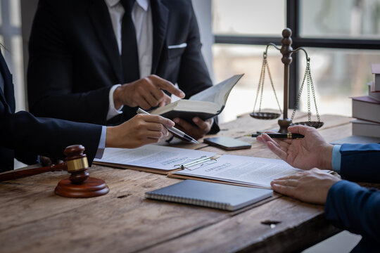 justice and law concept. male lawyer working in an office. Legal law, advice, and justice concept. The client is bringing the documents to clarify the law to the lawyer at the prosecutor's office.
