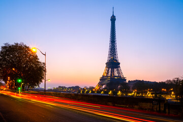 Fototapeta na wymiar Silhouette of the Eiffel Tower at dawn with blurred red lights of traffic. Paris, France
