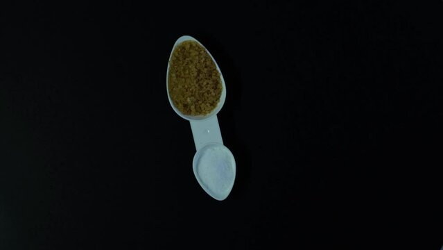 Brown Coconut palm sugar and sweetener Xylitol or Birch sugar. Video, clockwise rotation. Food additive E967. Concept of harm or benefit of sugar substitutes.