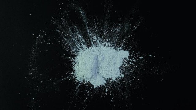 Titanium dioxide, TiO2. White pigment, chemical powder on dark surface, Rotation. Food additive E171. Titanium dioxide used in medicine, cosmetic, and skin care products.